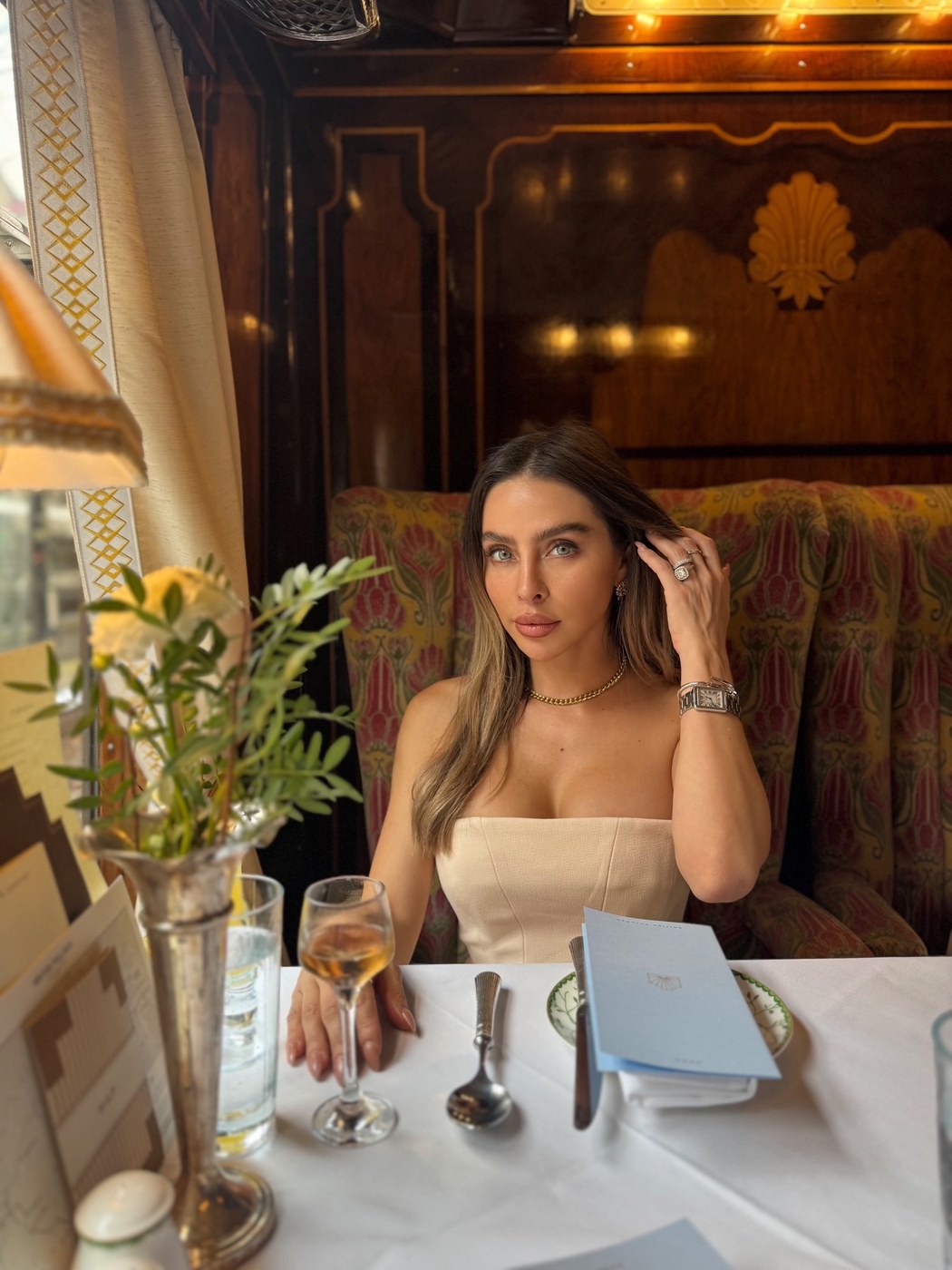 Lucia seated in an elegant restaurant